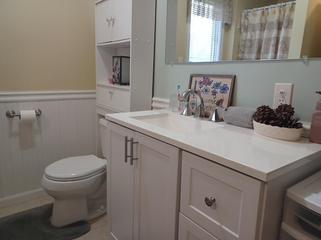 full bath featuring a wainscoted wall, vanity, toilet, and tile patterned floors