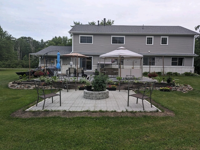 back of house with a yard, brick siding, a patio, and a gazebo