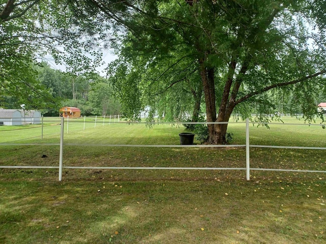 view of property's community with a yard and fence