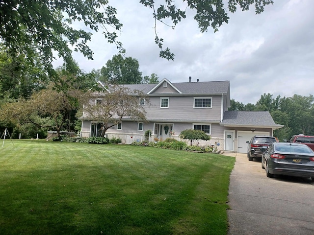 traditional home with a front yard, driveway, and an attached garage