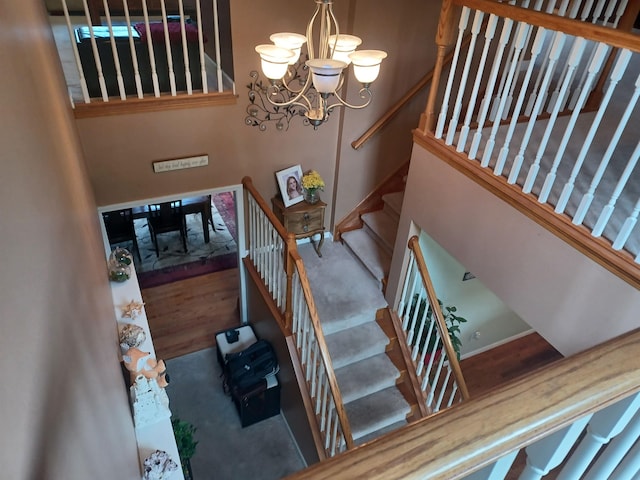 stairs featuring a notable chandelier