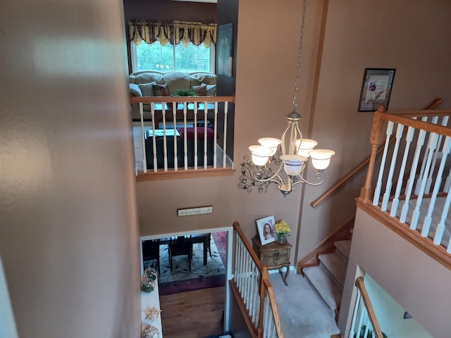 stairs with a notable chandelier