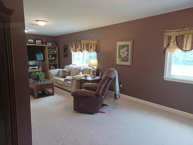 carpeted living area featuring baseboards