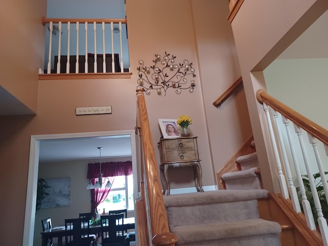 staircase featuring a towering ceiling