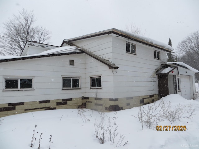 view of snow covered exterior with crawl space