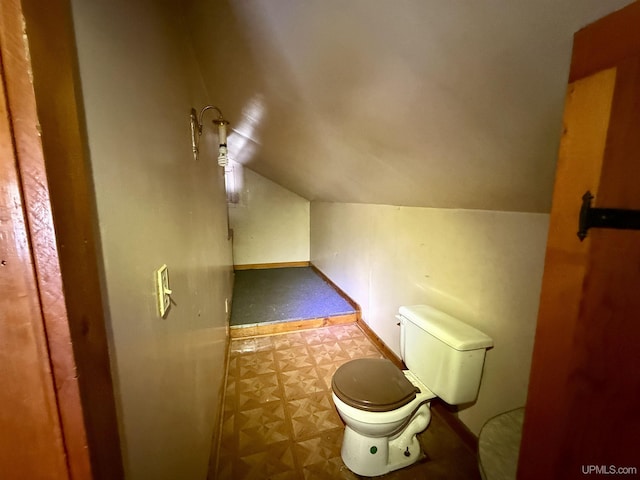 bathroom with toilet, baseboards, and vaulted ceiling