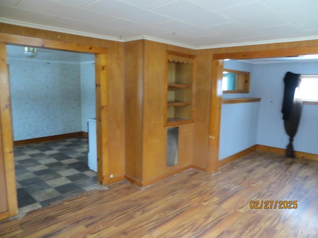 spare room with ornamental molding, wood finished floors, and baseboards