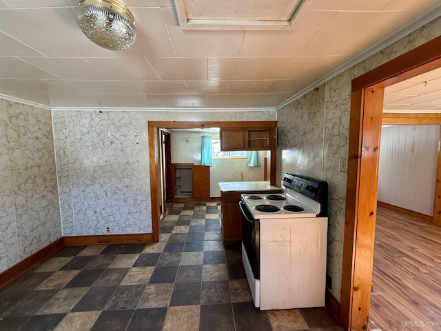 kitchen with baseboards, white electric range, and wallpapered walls