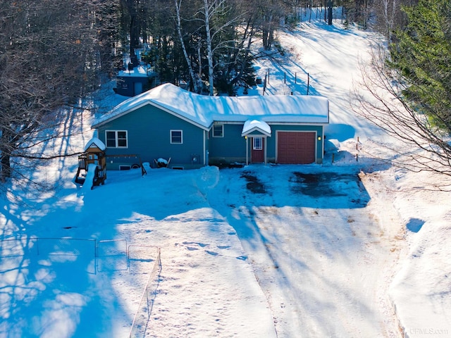 view of front facade featuring a garage, driveway, and fence