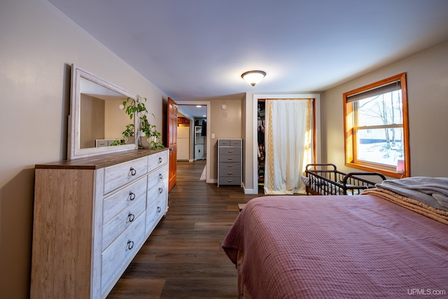 bedroom featuring baseboards, dark wood finished floors, and a closet