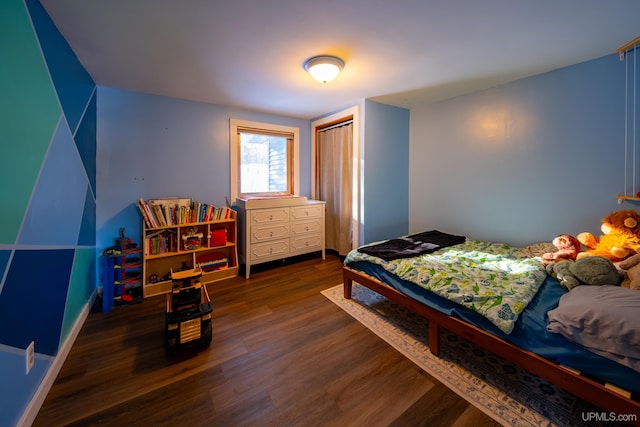 bedroom featuring a closet, baseboards, and wood finished floors