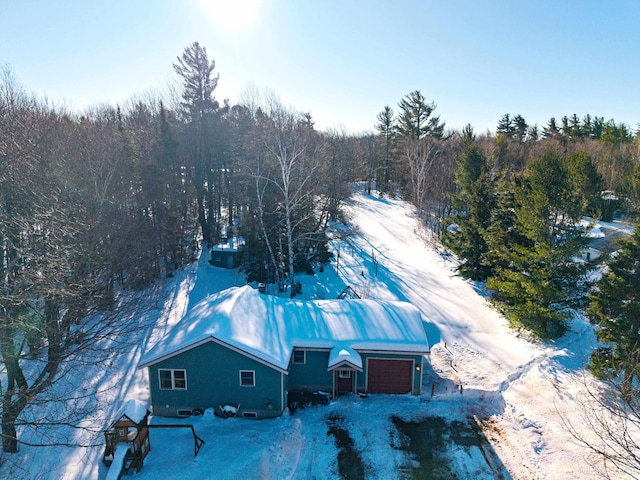 snowy aerial view featuring a forest view