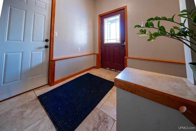 foyer entrance featuring baseboards and tile patterned floors