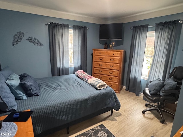 bedroom with light wood-style flooring and baseboards