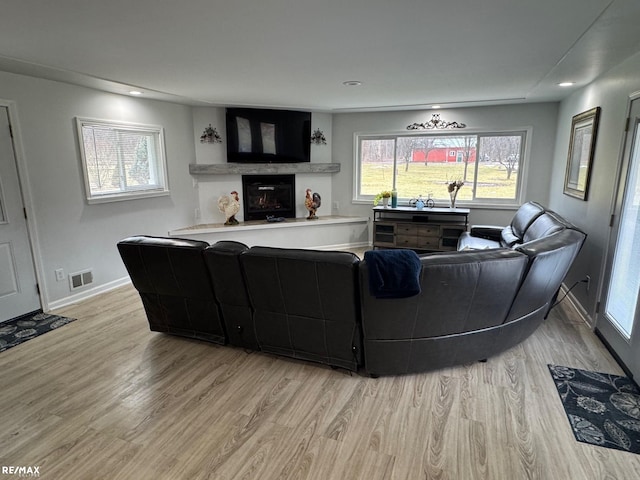 living room featuring recessed lighting, light wood-type flooring, visible vents, and baseboards