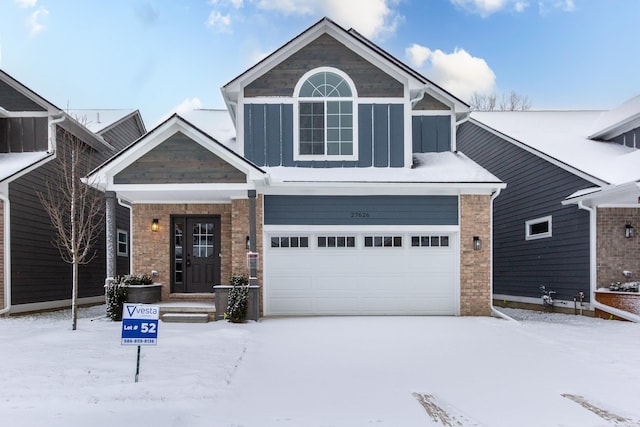 view of front of house with board and batten siding, brick siding, and a garage