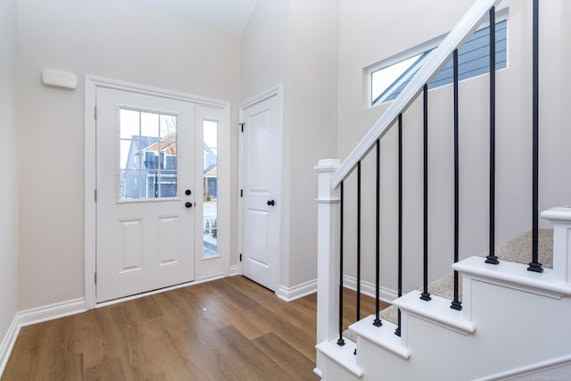 entryway featuring stairway, baseboards, and wood finished floors