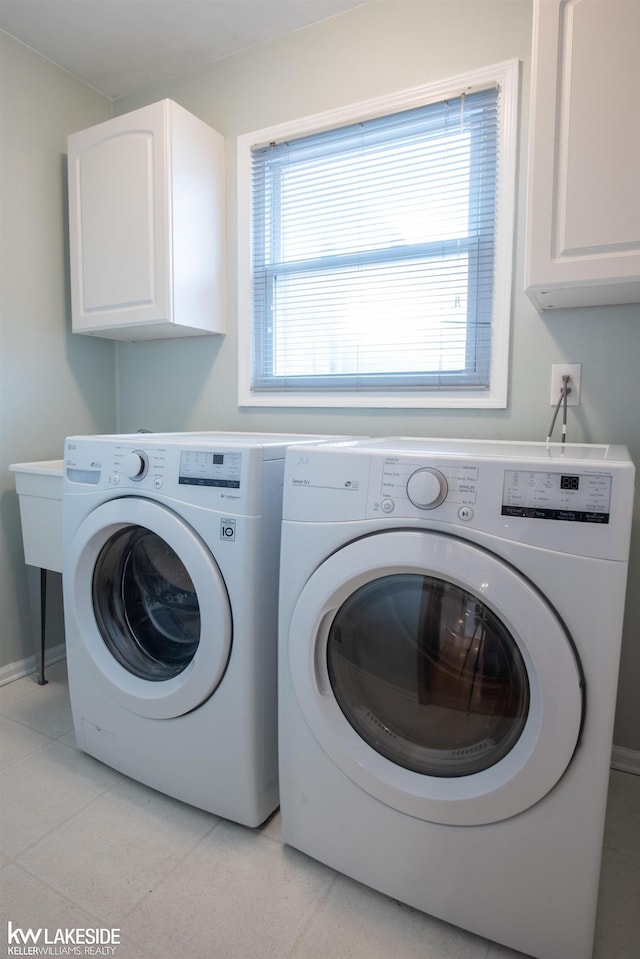 laundry room featuring washer and clothes dryer, cabinet space, and baseboards