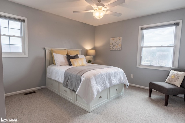 bedroom featuring baseboards, visible vents, a ceiling fan, and light colored carpet