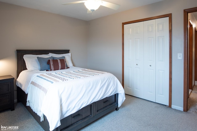 bedroom featuring a ceiling fan, a closet, light carpet, and baseboards