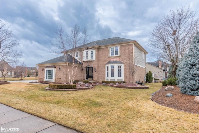 view of front facade with a front yard and brick siding