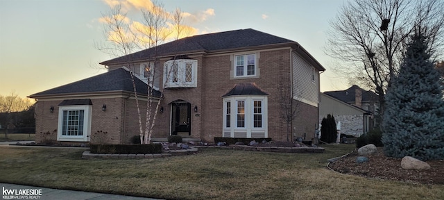 view of front facade featuring a lawn and brick siding