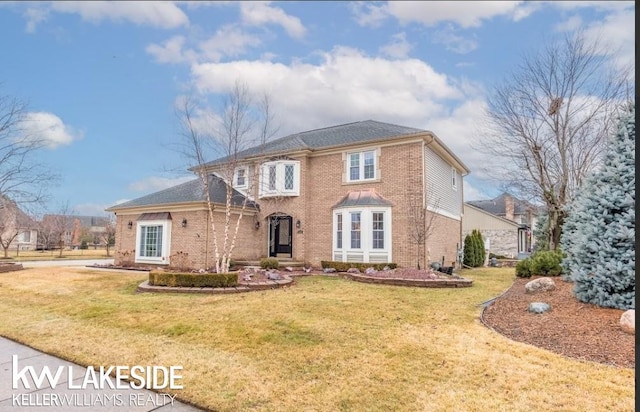 view of front of home featuring a front lawn and brick siding