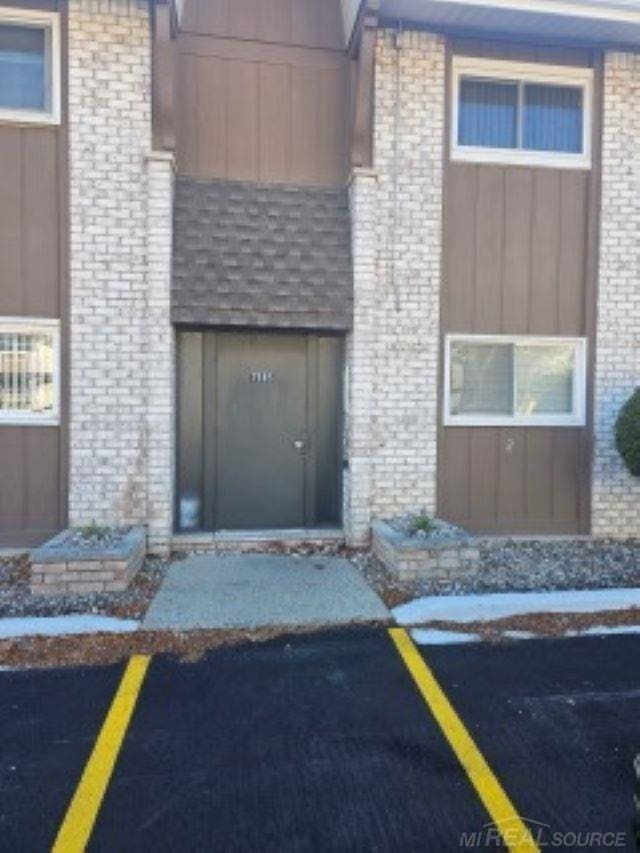 doorway to property featuring brick siding