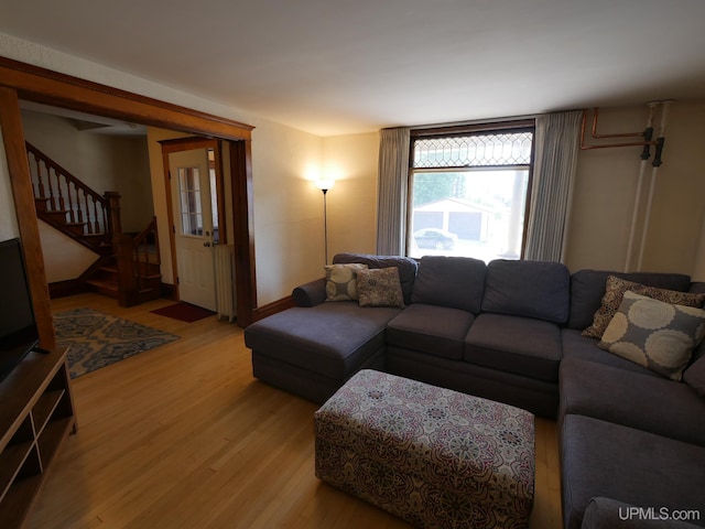 living room featuring light wood-type flooring and stairway