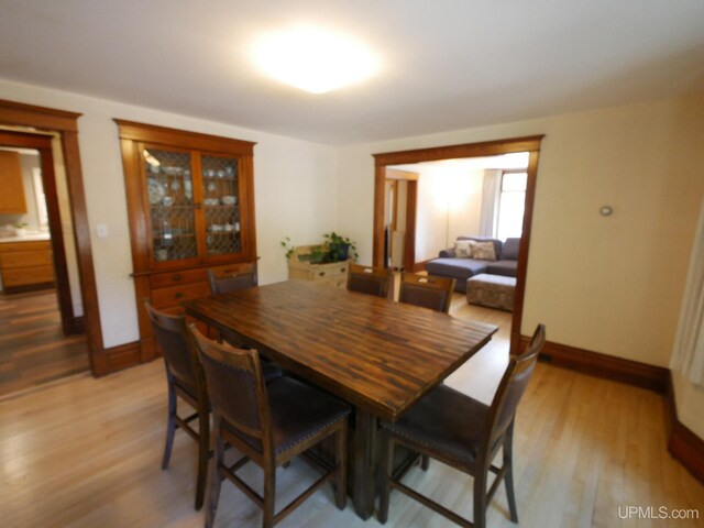 dining room featuring light wood-style floors and baseboards