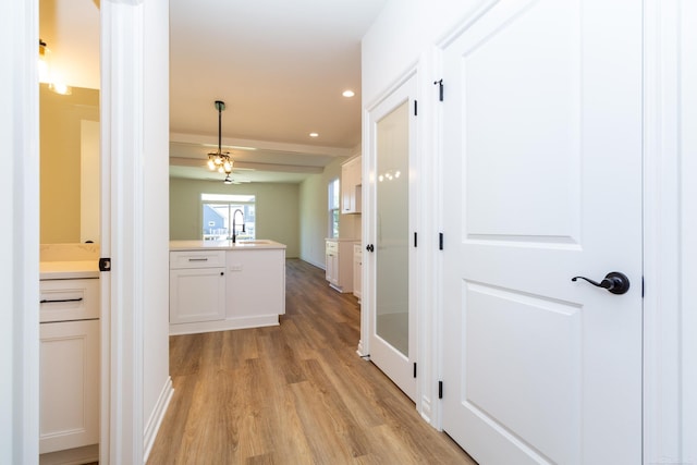 hall with recessed lighting, a sink, and light wood finished floors