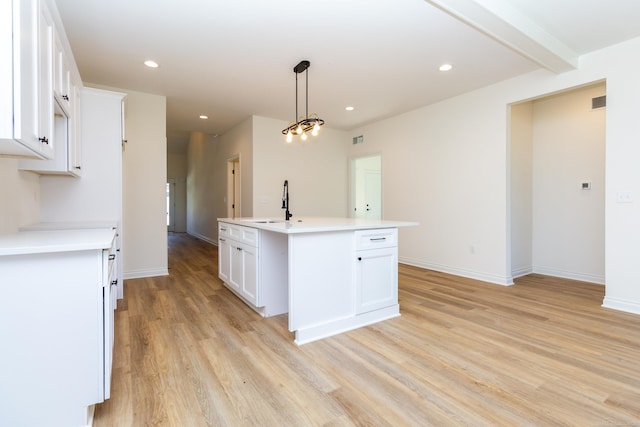 kitchen featuring light wood finished floors, a kitchen island with sink, and recessed lighting