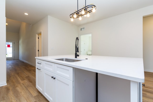 kitchen featuring a sink, visible vents, white cabinets, light wood-style floors, and light countertops