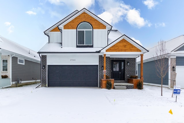 view of front of house featuring a garage, brick siding, and board and batten siding