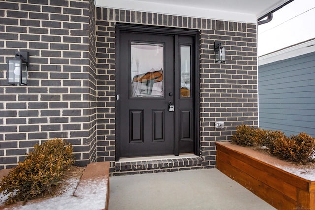 doorway to property with brick siding