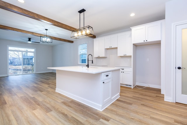 kitchen featuring a sink, white cabinets, and light wood-style floors