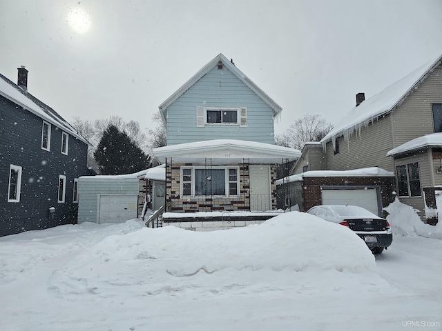 view of front facade featuring a garage, covered porch, and an outbuilding