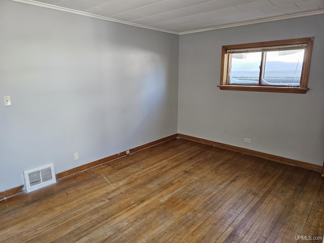 unfurnished room with wood-type flooring, visible vents, and baseboards