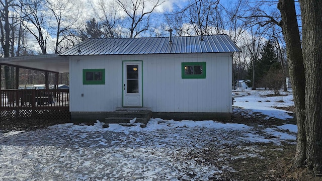 view of front of property featuring entry steps, metal roof, and a deck