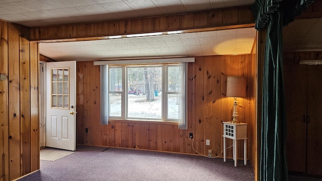 empty room with carpet floors and wood walls