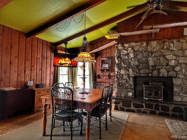 dining space with vaulted ceiling with beams and wood walls