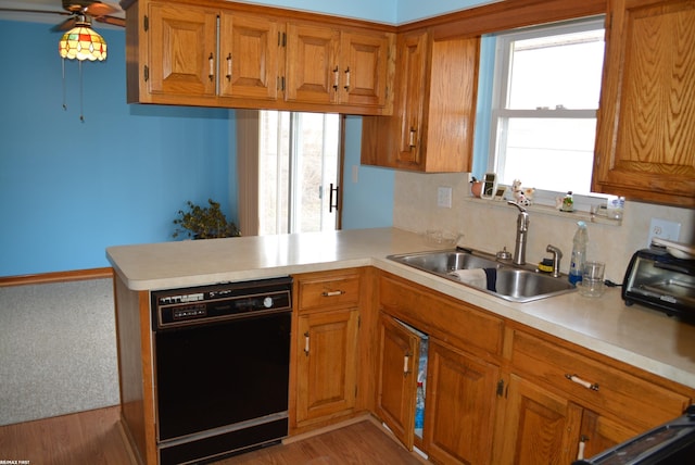 kitchen with black dishwasher, light countertops, and a sink