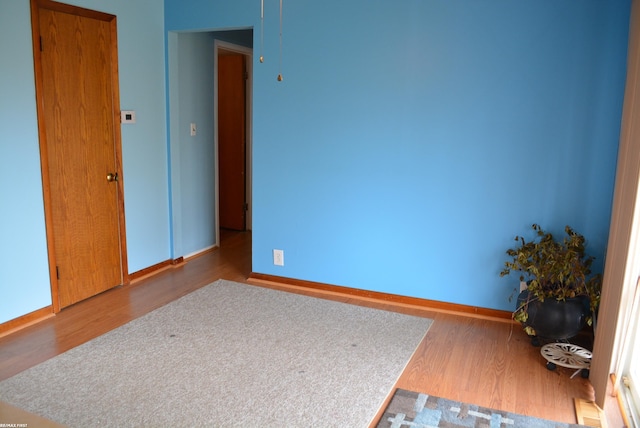 spare room with wood finished floors and baseboards