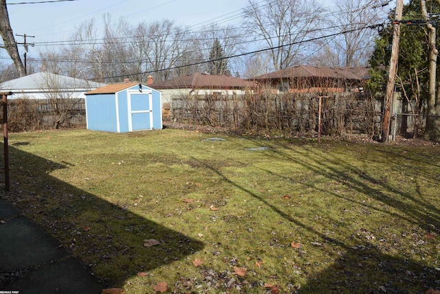 view of yard featuring an outbuilding, a shed, and a fenced backyard