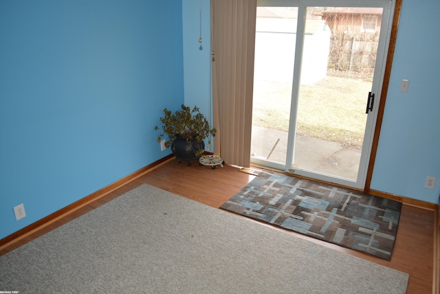 entryway with baseboards and wood finished floors