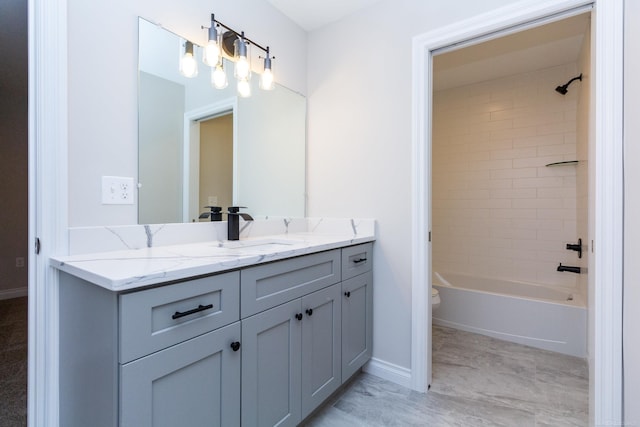 full bath with baseboards, shower / bath combination, vanity, and toilet