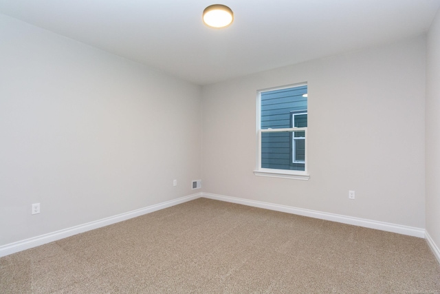 spare room featuring visible vents, baseboards, and carpet flooring