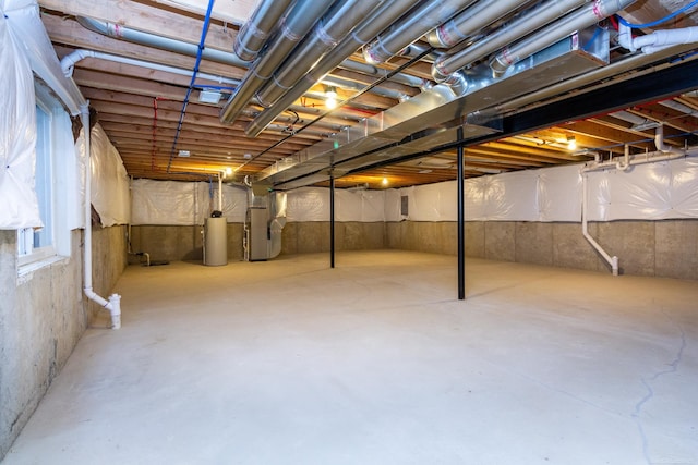 unfinished basement featuring water heater and heating unit