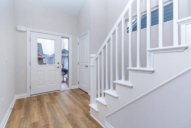 entrance foyer with wood finished floors, baseboards, and stairs