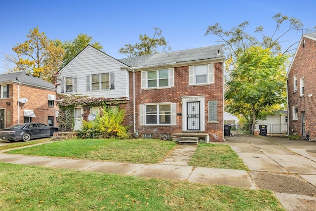 townhome / multi-family property with brick siding, driveway, and a front lawn